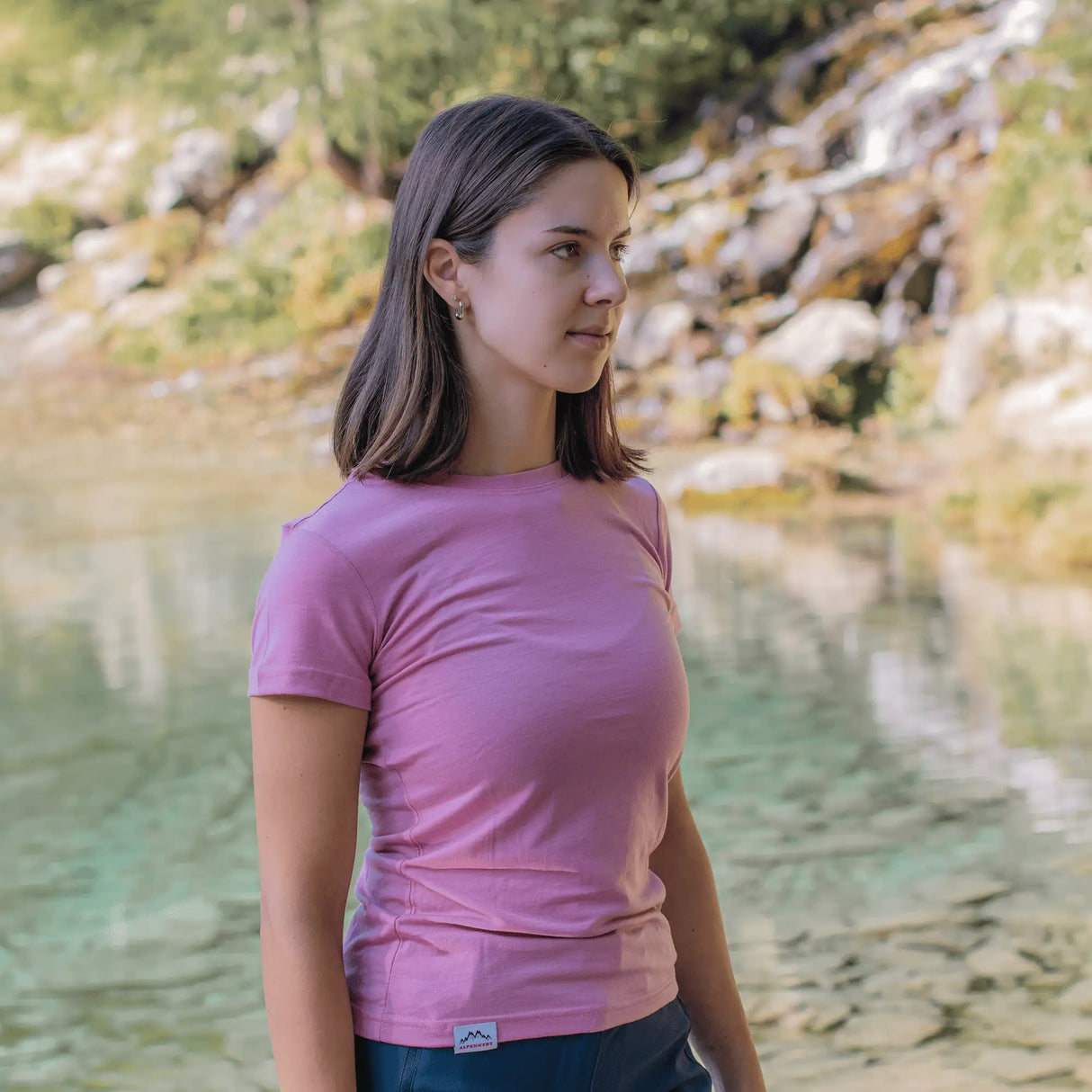 Frau trägt Merino Shirt Damen in Rosa, leichtes Merinowolle T-Shirt Damen für Outdoor Aktivitäten und sommerliche Wanderungen.