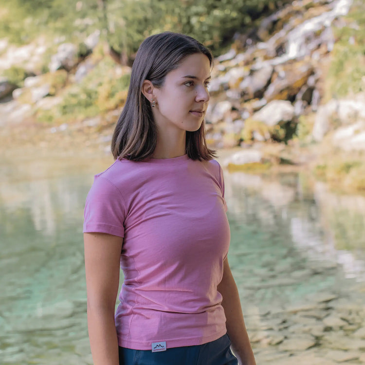 Frau trägt Merino Shirt Damen in Rosa, leichtes Merinowolle T-Shirt Damen für Outdoor Aktivitäten und sommerliche Wanderungen.