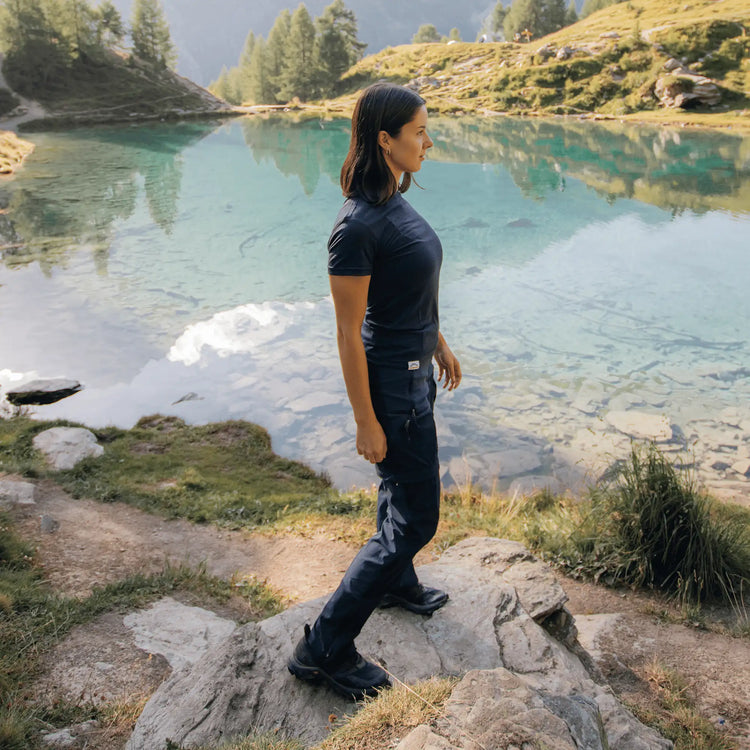 Frau am Bergsee im Merino Shirt Damen Blau, funktionales Merinoshirt Damen für Trekking, Reisen und sportliche Touren.