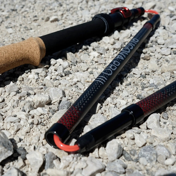 Faltbare Wanderstöcke aus Carbon auf Kiesboden, robuste Trekkingstöcke faltbar mit ergonomischem Griff für Outdoor Aktivitäten.